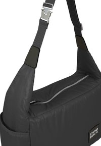 Borsa a tracolla nera imbottita con tasca con zip, manico intrecciato e accessori in metallo argentato. Presenta un'etichetta di branding sul lato.
