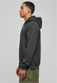Harmaa fleece-huppari, jossa on kenguru-tasku, nyöritettävä huppu, ribbikudottuja hihansuita ja helmaa. Sileä rakenne, rento istuvuus ja kestävä kangas.