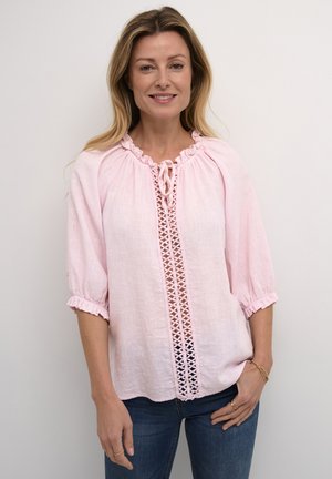 Hellrosa Leinenbluse mit rüschigem Ausschnitt und Puffärmeln. An der Vorderseite befindet sich ein dekoratives Häkelmuster und eine Bindedetail.