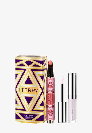 De Lip & Cheek Bliss Duo-set bevat een roze lip- en cheek-tint, een heldere lipgloss en een geometrische paarse en gouden doos met ornamentale details.