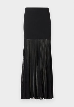 Jupe midi noire avec une partie supérieure ajustée et un panneau inférieur plissé en tissu transparent s'étendant du milieu de la cuisse jusqu'à l'ourlet.