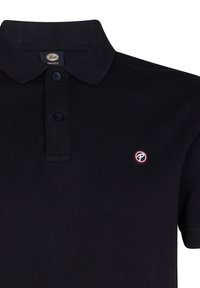 Polo in cotone nero con collo a punta, patta con tre bottoni e un piccolo logo rotondo con accenti rossi e blu sul petto.