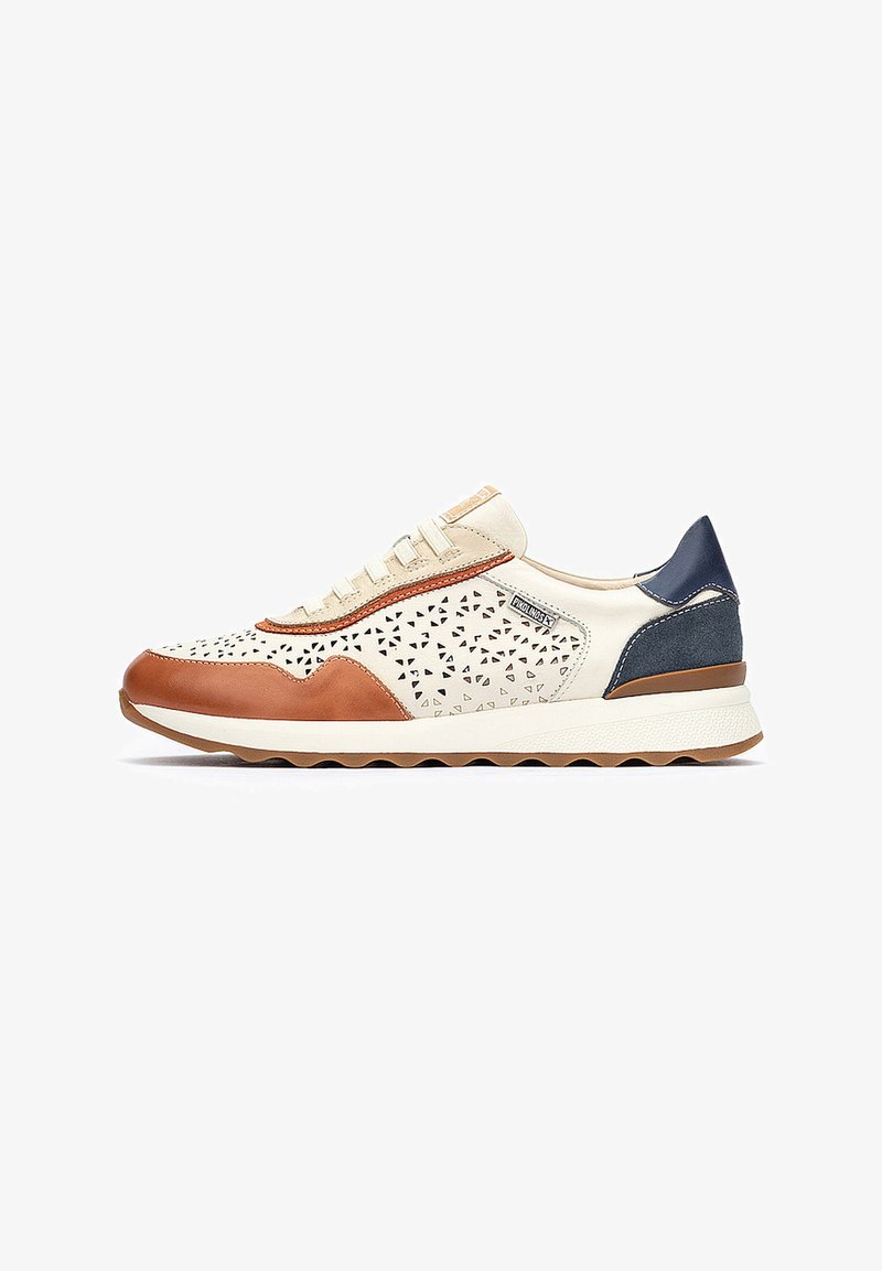Zapatilla de cordones con piel perforada color crema, detalles en cuero marrón, talón de gamuza azul y suela blanca texturizada para mayor agarre.