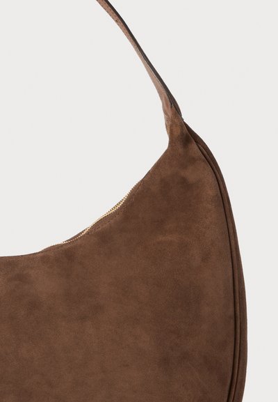Borsa a spalla in suede marrone con una silhouette curva, dotata di chiusura con zip e una superficie liscia e morbida. Tracolla unica per il trasporto.