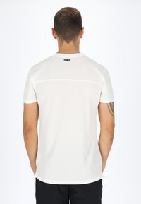 Hvid atletisk t-shirt med korte ærmer, rund hals og en vandret sømdetalje på den øverste ryg. Blød, letvægtig stof.