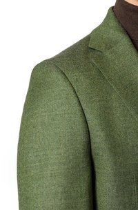 Zielony wełniany żakiet z wzorem w jodełkę, z wyraźnymi ramionami i klapami typu notch. Teksturowany materiał o gładkim wykończeniu.