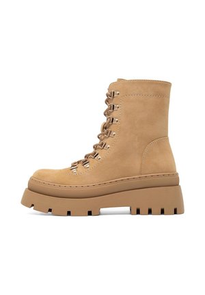 Beżowe zamszowe botki na kostkę z grubą platformą, z metalowymi oczkami i sznurówkami z przodu, gładką fakturą i okrągłym noskiem.