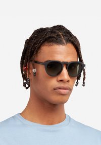 Must have mustrilahati mustrilast jooni ja tumepruunide läätsedega prillid. Omab ainulaadset lõikekuju, tekstuuriga käsi ja dekoratiivseid helmest accents.