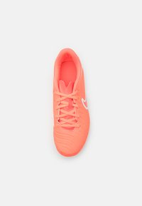 Chaussure de soccer corail vif avec une semelle extérieure en caoutchouc texturé, une tige synthétique lisse et des accents blancs. Dotée de six lacets légers.
