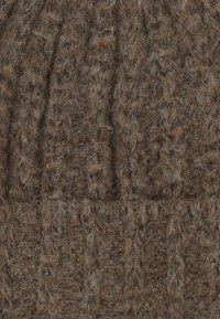 Brown knitted beanie with a ribbed texture, featuring subtle patterns. The fabric appears thick and fuzzy, indicating warmth and softness.