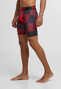 Boxers hommes en noir avec des motifs à carreaux rouges et des accents. Dotés d'une ceinture douce, d'un design ajusté et d'un tissu extensible pour le confort.
