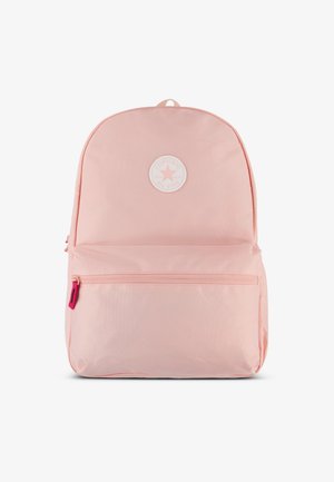 Rucsac roz cu un finisaj din țesătură netedă, având un buzunar cu fermoar în față, cu un cursor de fermoar negru și un patch rotund cu logo în centrul de sus.