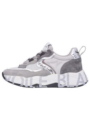 Scarpa atletica grigia con un mix di materiali in suede e metallici, dotata di una tomaia in mesh texture, suola spessa bianca e dettagli del marchio.