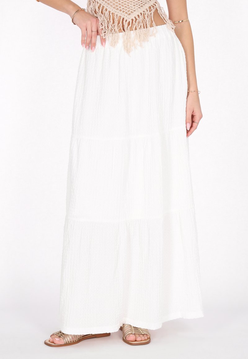 Witte maxi rok van textiel met gelaagde lagen. Kenmerkt zich door een relaxte pasvorm, vloeiende design en is gecombineerd met sandaaltjes met banden.