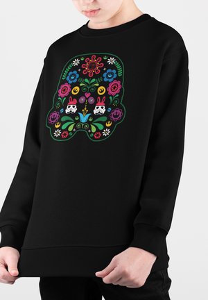 Sudadera negra con un diseño floral colorido en forma de casco, con flores, conejos y estrellas. Material suave y corte holgado.