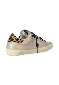 Baskets en cuir beige clair avec lacets noirs, semelle en caoutchouc texturé couleur tan et accent en imprimé léopard sur le talon.