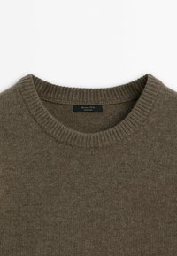 Maglione marrone lavorato a maglia con scollo rotondo a coste. Texture liscia con un motivo sottile e uniforme. Etichetta "Made in China" situata all'interno.