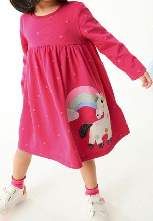 Robe rose à manches longues avec taille froncée, ornée d'un appliqué licorne et arc-en-ciel. Matière en coton doux, avec des accents à pois partout.