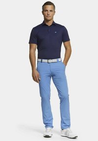 Marineblauw poloshirt, lichtblauwe broek, witte riem en grijze golfschoenen. Rechte stof; slim fit met korte mouwen; geen patronen of opvallende accenten.