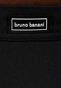 Schwarzer Badeanzugstoff mit strukturierten Oberflächen; verfügt über ein eingenähtes Etikett mit "bruno banani" in weißem Text auf einem kontrastierenden schwarzen Hintergrund.