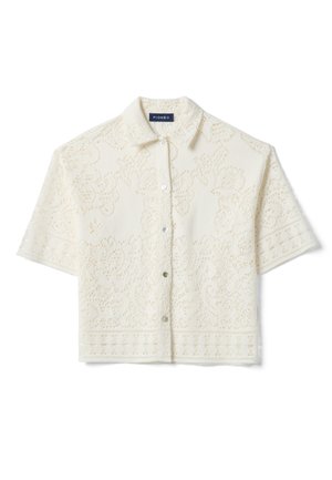 Chemise courte à manches courtes crème avec motif en dentelle ajourée florale et col pointu, coupe courte.