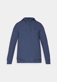 Sweat à capuche zippé bleu marine en tissu texturé, doté d'une capuche avec cordon de serrage, de deux poches avant et d'un petit logo de marque sur la poitrine.