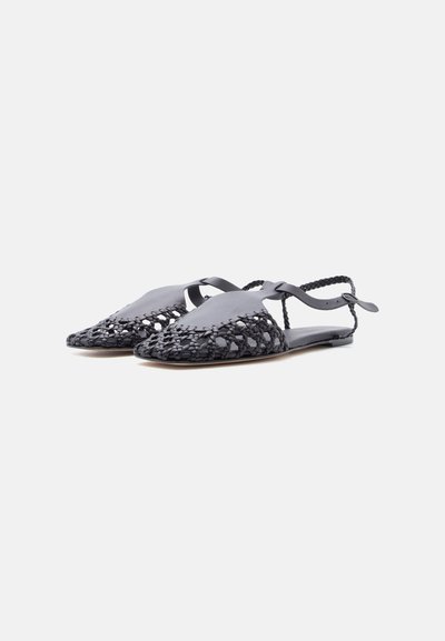 Μαύρα επίπεδα σανδάλια με υφαντές μυτερές μύτες και λουράκια στον αστράγαλο, με λείο επάνω μέρος και πλεχτό λουράκι πίσω.