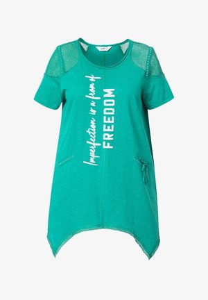 T-shirt turchese con maniche corte, dettagli in rete, orlo curvo e testo stampato. Presenta borchie decorative e una tasca laterale.
