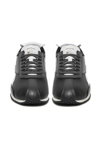 Mustad nahast tossud hallide paelte ja valgete detailidega. Omavad õmblustega kaunistusi ja tekstureeritud kummist talla. Klassikalise sportliku disainiga.