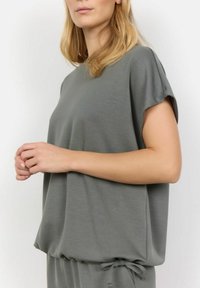 Kortærmet, løstsiddende bluse i blødt, tekstureret grå materiale med rund halsudskæring og justerbar snor til kanten.