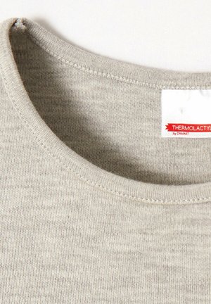 Maglietta in maglia morbida di un grigio chiaro con scollatura rotonda. Presenta un'etichetta con la scritta "THERMOLACTYL by DAMART." Testura e cuciture visibili.