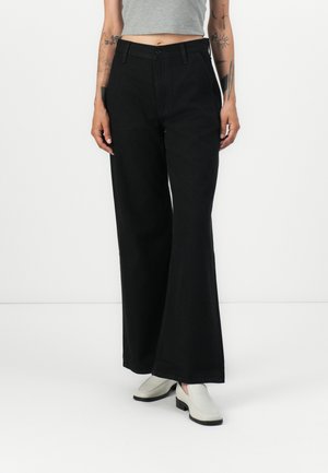 Black wide-leg trousers with a high waist, featuring a button closure and side pockets. Made from textured denim fabric.