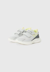 Grey athletic shoes featuring adjustable Velcro straps, a textured surface, bright yellow accents, and a cushioned white sole.