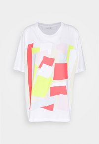 Camiseta blanca de manga corta con un patrón abstracto multicolor en rosa, amarillo y azul claro, con un corte relajado y escote en crew.