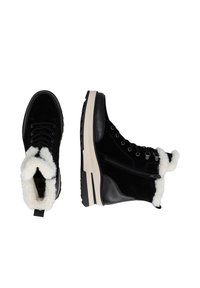 Zwarte suède en leren laarzen met een fluffy witte bontkraag en een witte loopzool. Voorzien van veters en een zijrits voor gemakkelijk aan- en uittrekken.