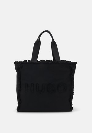 Bolso tote negro con asas dobles, bordes deshilachados y logo en relieve con textura "HUGO" en el frente.