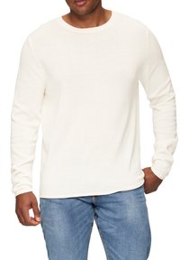 Lange mouw crewneck shirt van licht cremewitte stof, met een geribbelde textuur en een relaxte pasvorm, gedragen met blauwe denim jeans.