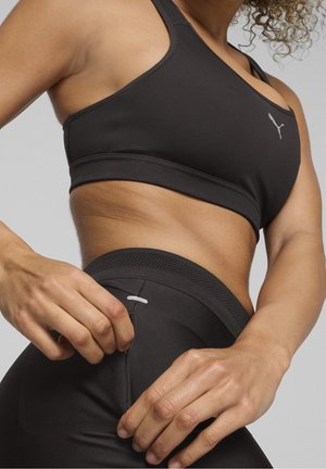 Sort sports-bh med racerback-design, glat tekstur og et lille logo. Sorte leggings med en lomme og mesh-detaljer.