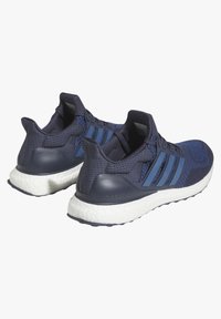 Ténis azul marinho com parte superior em malha, três riscas refletoras e suporte para o calcanhar texturizado. Sola branca almofadada com a etiqueta "ultra boost".