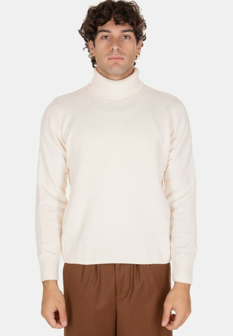 Maglione girocollo crema realizzato in maglia a costine, con maniche lunghe e una vestibilità comoda, abbinato a pantaloni marroni.