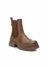 Stivaletto in pelle marrone con pannelli elastici laterali, un manico, suola grossa e cuciture a contrasto per un tocco di stile.