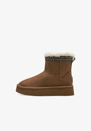 Stivale alla caviglia in suede marrone con colletto in pelliccia bianca e motivo decorativo nella parte superiore. Presenta una suola in gomma piatta e un'etichetta sul retro.