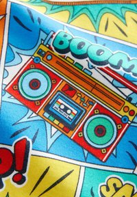 Kolorowa tkanina z retro wzorem boomboxa, z zielonymi głośnikami, odtwarzaczem kaset oraz żywymi akcentami w stylu komiksowym w kolorze żółtym i niebieskim.