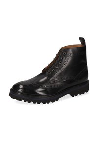 Botín de cuero negro hasta el tobillo con detalles de brogue, puntera redonda, seis ojales, paneles laterales texturizados y suela robusta. Asa decorativa en el talón.