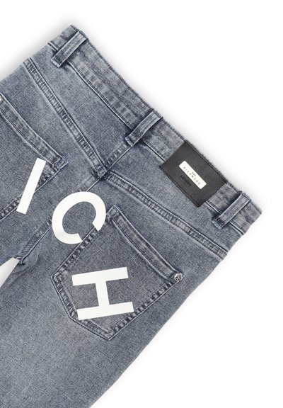 Jeans in denim di blu medio con due tasche posteriori caratterizzate da lettere bianche in blocco. Etichetta del brand in pelle sulla vita, dettaglio di chiusura con bottone.