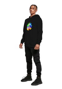 Černá mikina s barevným grafikem symbolu míru a designem s kapkami. K tomu černé cargo kalhoty a černé tenisky dotvářejí celý outfit.