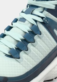 Baskets de course bleu clair avec un dessus texturé, des accents bleu foncé, des lacets intégrés et une semelle flexible ; оснащены un design avec motif et des matériaux durables.