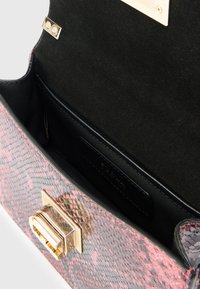 Τσάντα χειρός με τύπωμα φίδι σε ροζ και μαύρο χρώμα, με λαμπερό χρυσό κούμπωμα. Στο εσωτερικό υπάρχει ομαλή μαύρη επένδυση και θήκη για πιστωτική κάρτα.