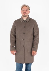 Cappotto in lana marrone con colletto, chiusura a bottoni, due tasche frontali e cuciture a contrasto sul colletto.