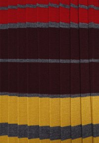 Tessuto a maglia con strisce orizzontali in rosso, bordeaux scuro, grigio e giallo. La texture è liscia con un motivo a coste regolari.